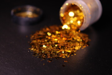 transparent jar with golden shiny shiny glitter on a black background