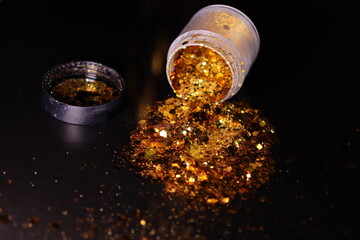 transparent jar with golden shiny shiny glitter on a black background