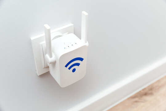 Wireless Wi-Fi repeater on white wall indoors