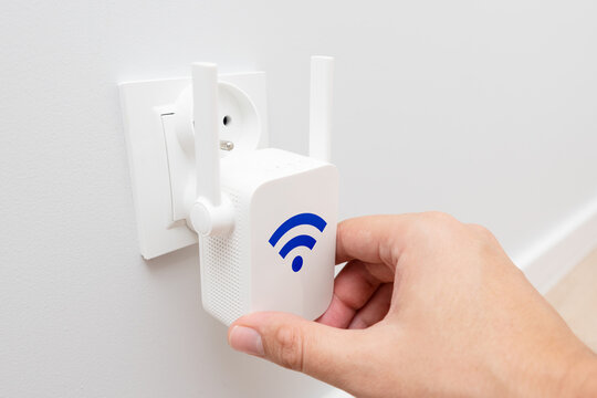 Wireless Wi-Fi repeater on white wall indoors