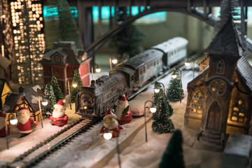 Miniature of winter scene with Christmas houses, train station, trees, covered in snow. Nights scene. New year or Christmas concept.