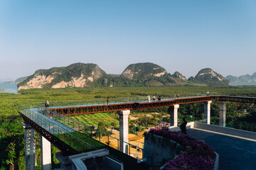 Fototapeta premium Visitors enjoy breathtaking views from an observation bay in Thailand on a clear, sunny day with lush scenery