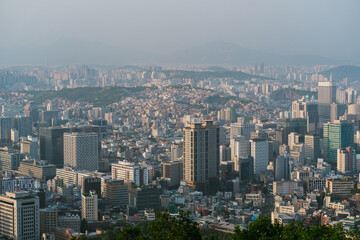 Fototapeta premium Aerial view of bustling Seoul, South Korea showcasing urban development amid hazy skies during late afternoon