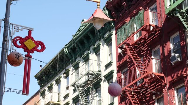 New York City, United States. Manhattan Chinatown Mott street, chinese ethnic district buildings architecture, USA. American red brick house in little China. Fire escape ladder in NYC. Paper lanterns.