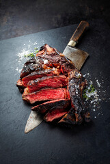 Barbecue dry aged chianina rib of beef steak served with crystal salt and thyme as close-up on a...
