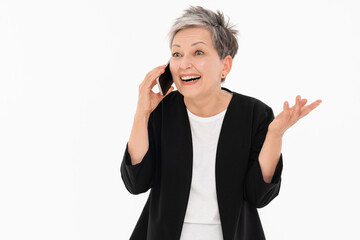 Happy mature businesswoman talking on mobile phone, looking away, standing by white background....