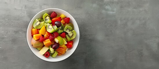 Bowl of fresh healthy fruit salad on a grey background Panorama banner with copyspace