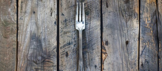 Silver fork set against a wooden background. Copy space image. Place for adding text and design