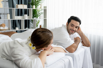 Fototapeta premium Caucasian couple customer enjoying relaxing anti-stress spa massage and pampering with beauty skin recreation leisure in day light ambient salon spa at luxury resort or hotel. Quiescent