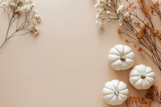 A minimalist flat lay display featuring handmade plaster pumpkins and dried flowers on a beige background, perfect for autumn and Halloween decor ideas