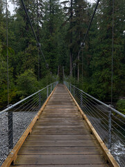 Empty, wooden suspension bridge over a mountain stream