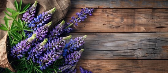 Fototapeta premium Lupine flowers and summer accessories arranged on a wooden surface. Copy space image. Place for adding text and design