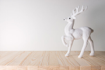 Holiday concept with white reindeer on wooden table. Creative Christmas or New Year background.