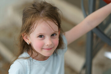 Little cute girl walking on stairs holding handrail. Children's exploration concept