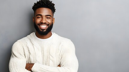 Fototapeta premium A smiling black man with a beard in a white sweater