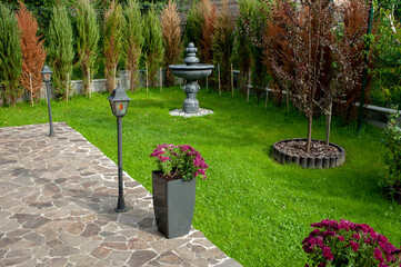 Neat paved patio with sitting area and small garden near wooden fence