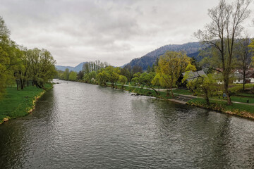 Fototapeta premium Rzeka Dunajec - Krościenko nad Dunajcem. Widok z mostu. W tle góry Pieniny. Pochmurny wiosenny dzień. 