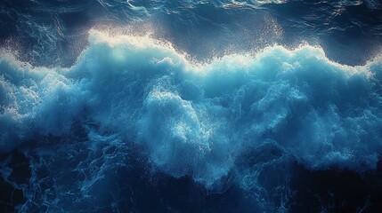 an Top-down view of a frothy blue sea surface, captured from above with the sun reflecting off the waves.