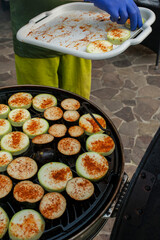 The cook prepares grilled vegetables, grilled zucchini, barbecue. Photo of food.