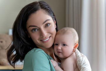 Beautiful nurse medical worker in gloves holding newborn baby in hands