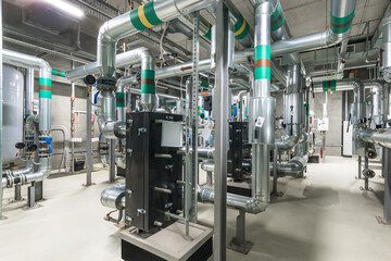 A detailed view of an industrial facility reveals intricate piping systems and machinery arranged...