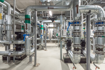 A complex arrangement of stainless steel pipes connects various valves and equipment in a modern...