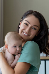 Beautiful nurse medical worker in gloves holding newborn baby in hands