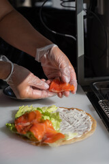 Chef prepares flatbread with salmon. Vertical photo. Quesadilla. 