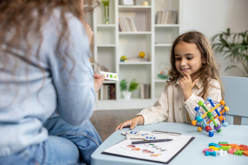 Female speech therapist having a training session with a long-haired girl