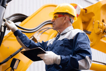 Machinery tractor mechanic with tablet computer checks hydraulic piston hose system equipment on excavator. Concept industry truck maintenance © Parilov