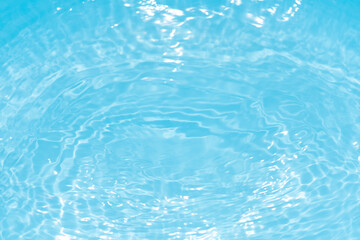 Blue water with ripples on the surface. Defocus blurred transparent blue colored clear calm water surface texture with splashes and bubbles. Water waves with shining pattern texture background.