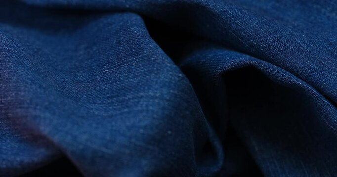 A background of blue crumpled denim jeans. Close up.