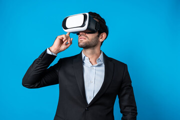 Caucasian business man planning financial plan while using VR goggle. Professional project manager standing and touching VR headset while using visual reality glasses to connect metaverse. Deviation.