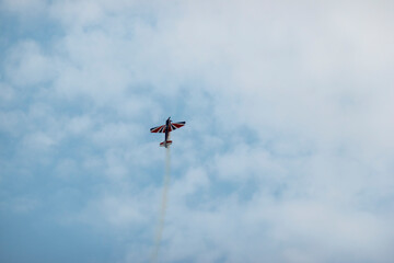 A pilot flies an aerobatic propeller plane in the sky