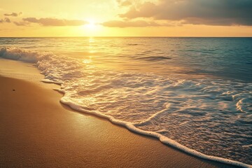 Golden sunset over the ocean with waves crashing on the sandy beach