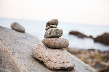 serene beach scene with smooth rocks stacked in a balanced formation. The tranquil atmosphere evokes a sense of zen, harmony, and peace, symbolizing balance and mindfulness in nature