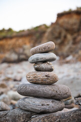 serene beach scene with smooth rocks stacked in a balanced formation. The tranquil atmosphere evokes a sense of zen, harmony, and peace, symbolizing balance and mindfulness in nature