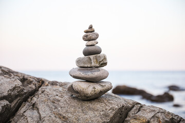 serene beach scene with smooth rocks stacked in a balanced formation. The tranquil atmosphere evokes a sense of zen, harmony, and peace, symbolizing balance and mindfulness in nature