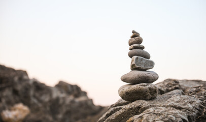 serene beach scene with smooth rocks stacked in a balanced formation. The tranquil atmosphere...