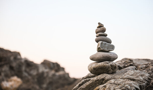 serene beach scene with smooth rocks stacked in a balanced formation. The tranquil atmosphere evokes a sense of zen, harmony, and peace, symbolizing balance and mindfulness in nature