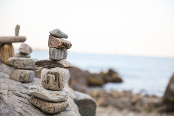 serene beach scene with smooth rocks stacked in a balanced formation. The tranquil atmosphere evokes a sense of zen, harmony, and peace, symbolizing balance and mindfulness in nature