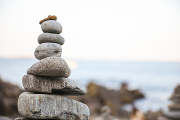 serene beach scene with smooth rocks stacked in a balanced formation. The tranquil atmosphere evokes a sense of zen, harmony, and peace, symbolizing balance and mindfulness in nature