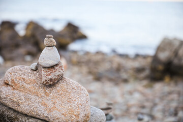 serene beach scene with smooth rocks stacked in a balanced formation. The tranquil atmosphere evokes a sense of zen, harmony, and peace, symbolizing balance and mindfulness in nature
