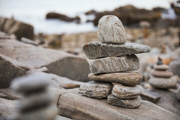 serene beach scene with smooth rocks stacked in a balanced formation. The tranquil atmosphere evokes a sense of zen, harmony, and peace, symbolizing balance and mindfulness in nature
