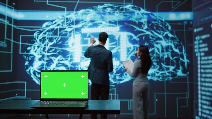 Teamworking AI technicians using green screen laptop for business data analysis. Team of IT experts...