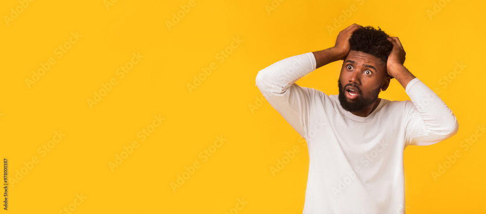 Wall mural Shocked african american guy with open mouth touching his head and looking at copy space, seeing shocking advertisement, panorama