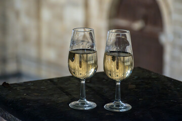 Sherry wine glasses with fino and old church on background at night in Jerez de la Frontera, wine glasses outdoor, cityview, Andalusia, Spain