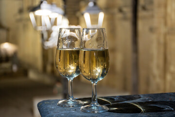 Sherry wine glasses with fino and old church on background at night in Jerez de la Frontera, wine glasses outdoor, cityview, Andalusia, Spain