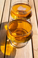Tasting of french apple cider brut in glass made from new harvest apples outdoor in sunny orchard