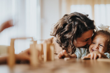 A joyful mother with her daughters enjoying a playful moment together at home. The scene captures warmth, love, and family bonding in a comfortable setting.